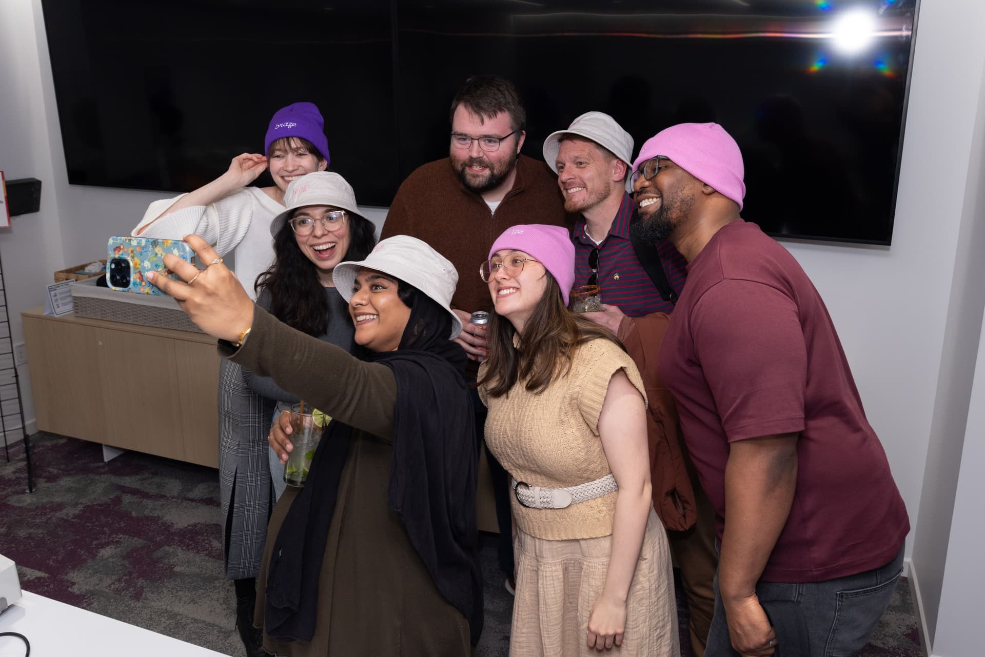 a group of people are taking a selfie together in a room .